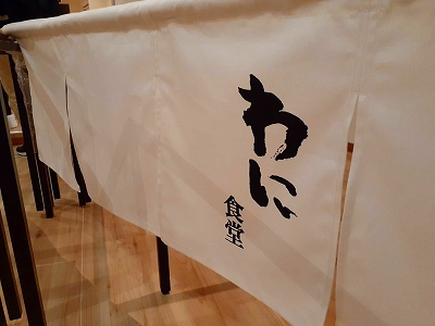 店主さんの娘さんが小学校一年生の時に初めての書道教室で書いた文字が暖簾（のれん）に使われています。