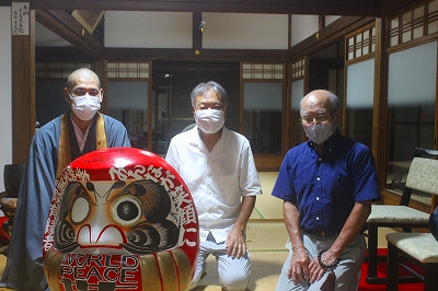 世界平和を願う達磨さんを前に、檀家総代さんたちと話している様子です。